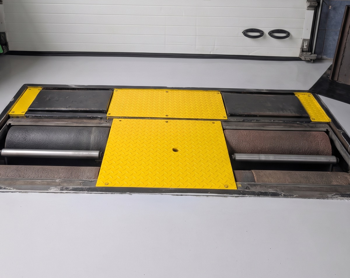 Im Boden eingelassener Rollenbremsprüfstand mit gelben Abdeckplatten